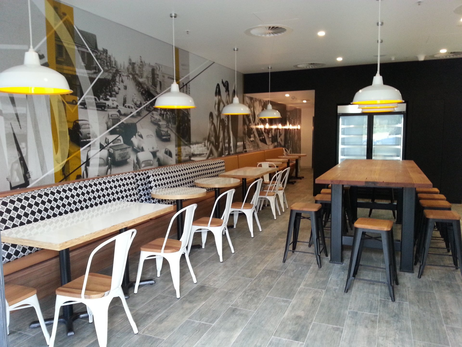 A restaurant with tables and chairs and a refrigerator