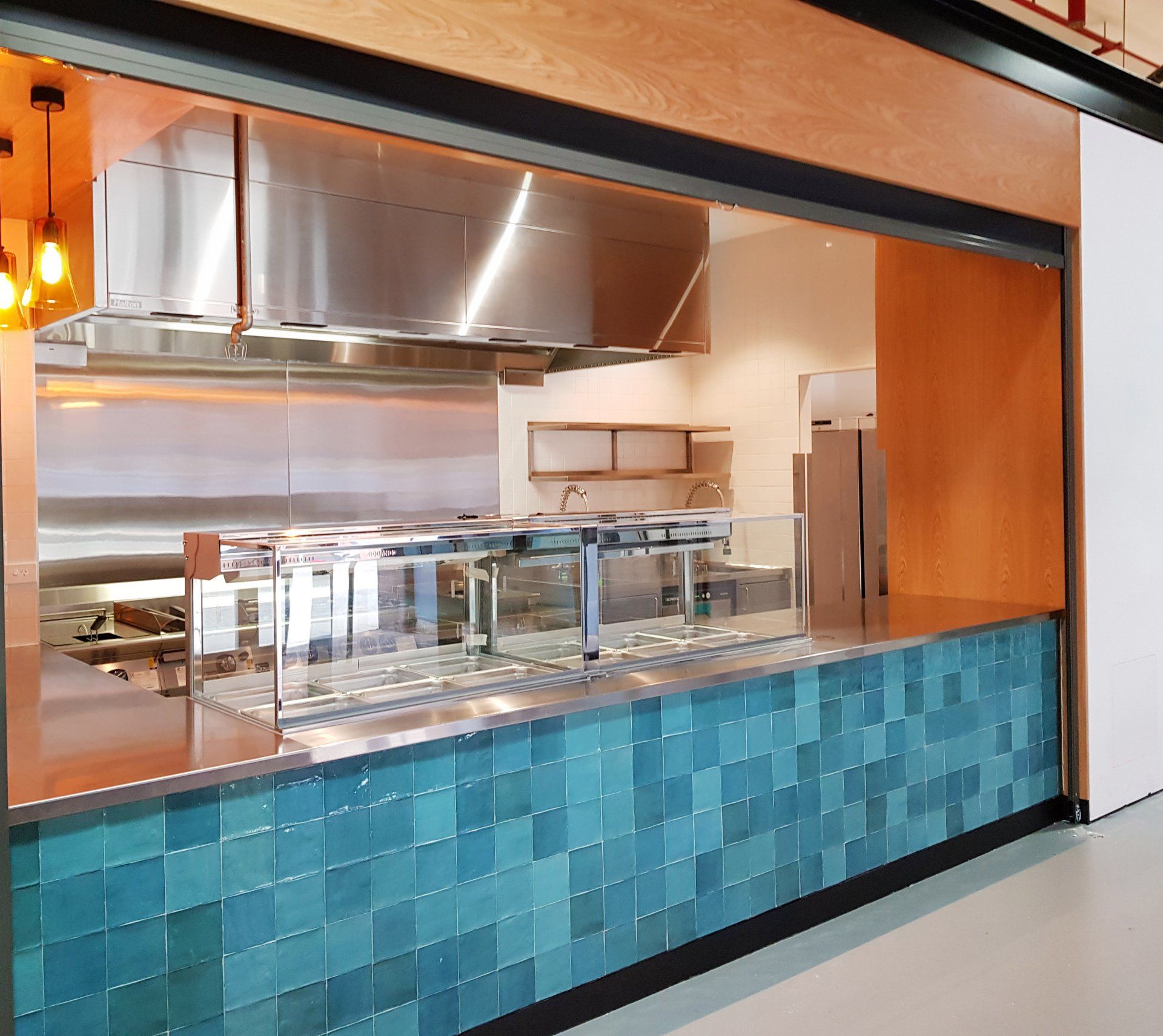 A kitchen with stainless steel appliances and blue tiles