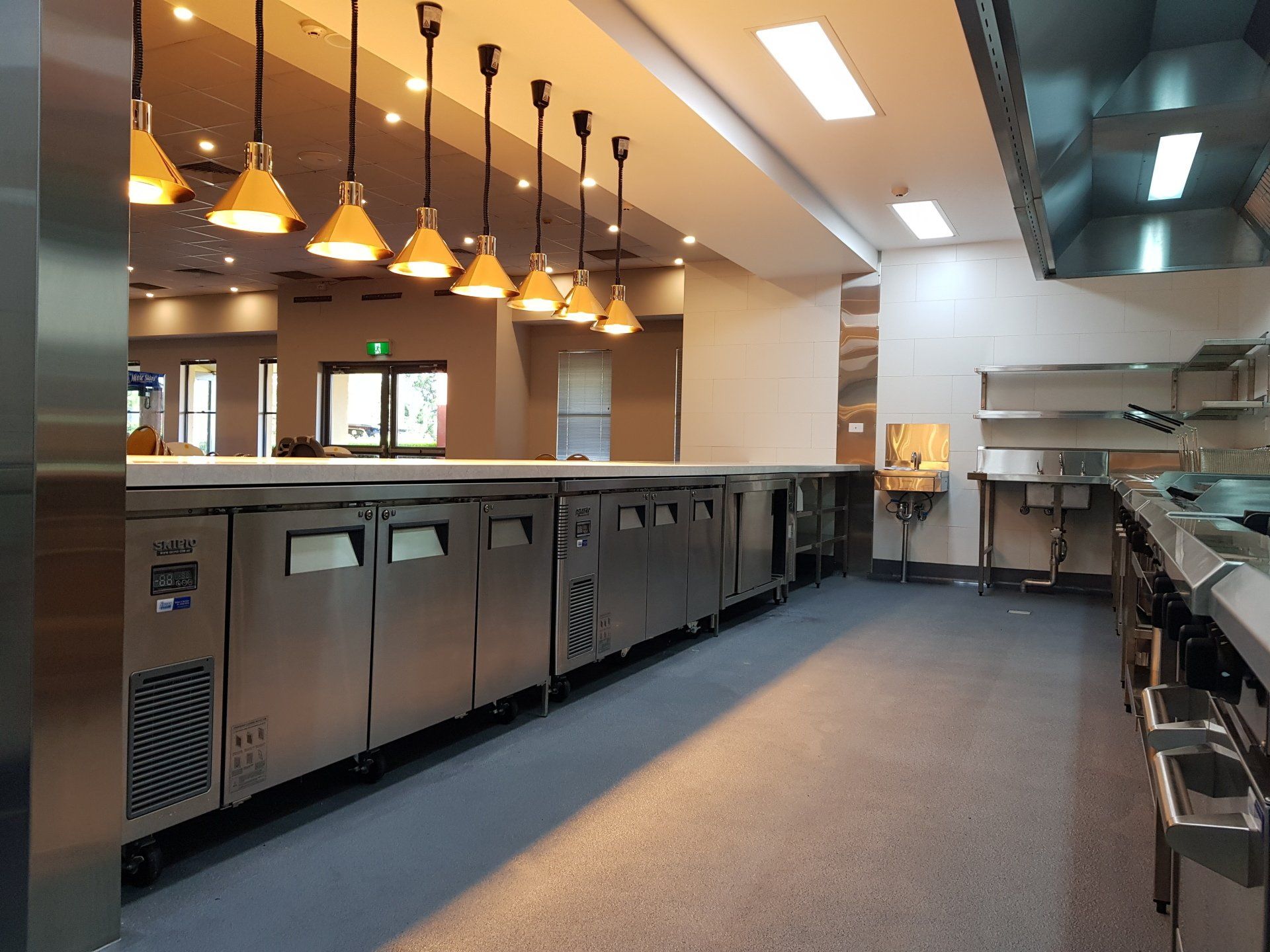 A large kitchen with a lot of stainless steel appliances