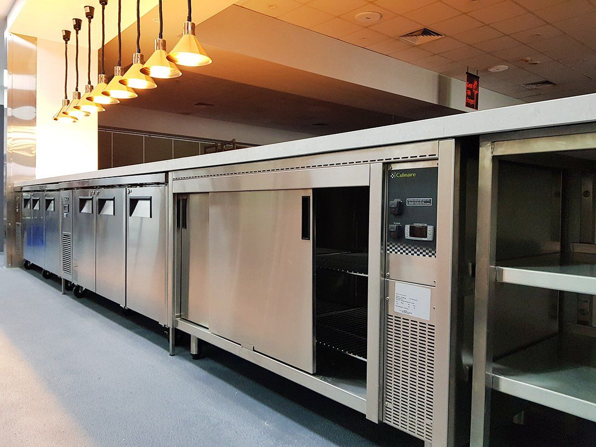 A long row of stainless steel appliances in a kitchen