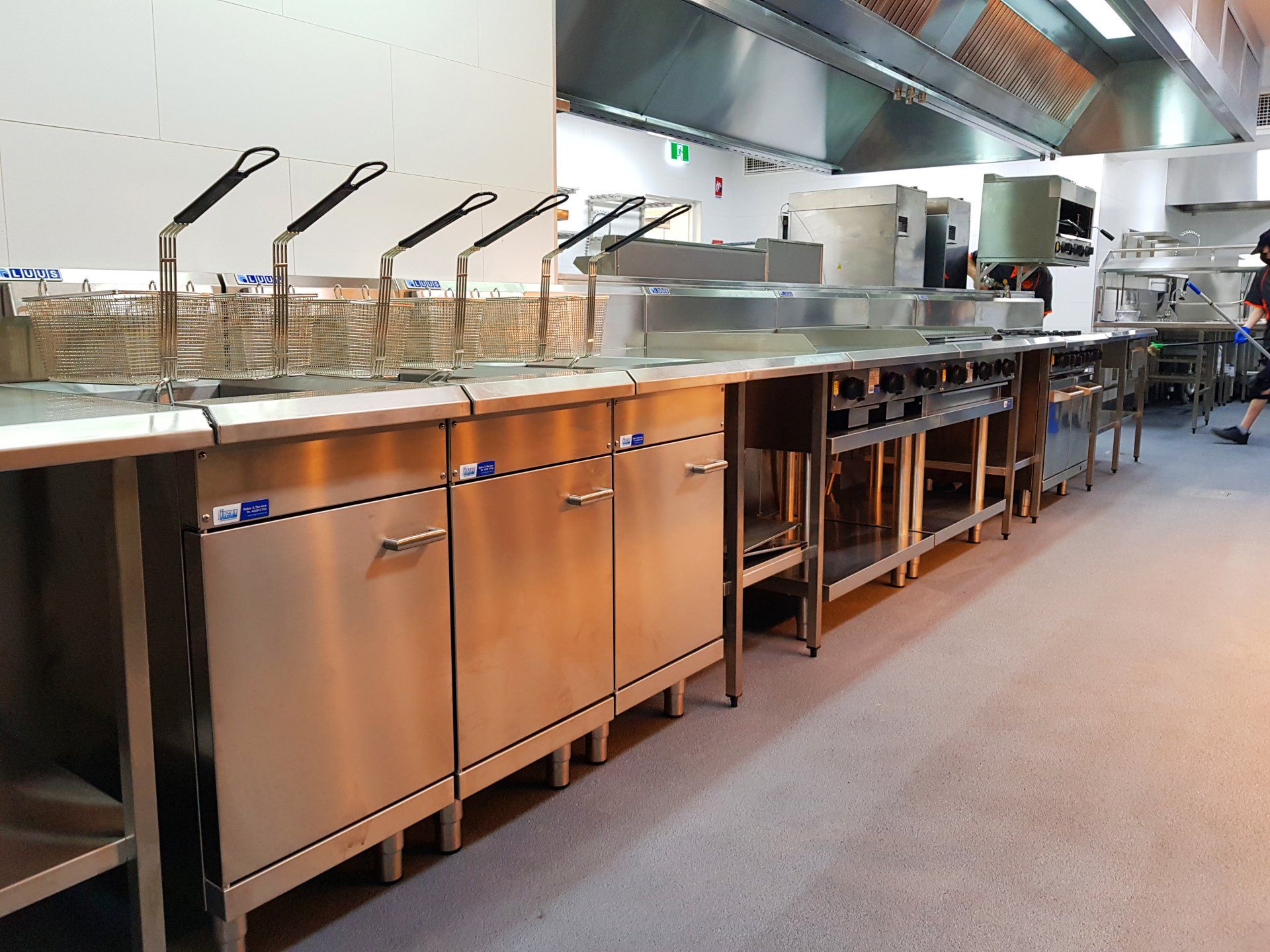 A kitchen with a lot of stainless steel appliances and cabinets
