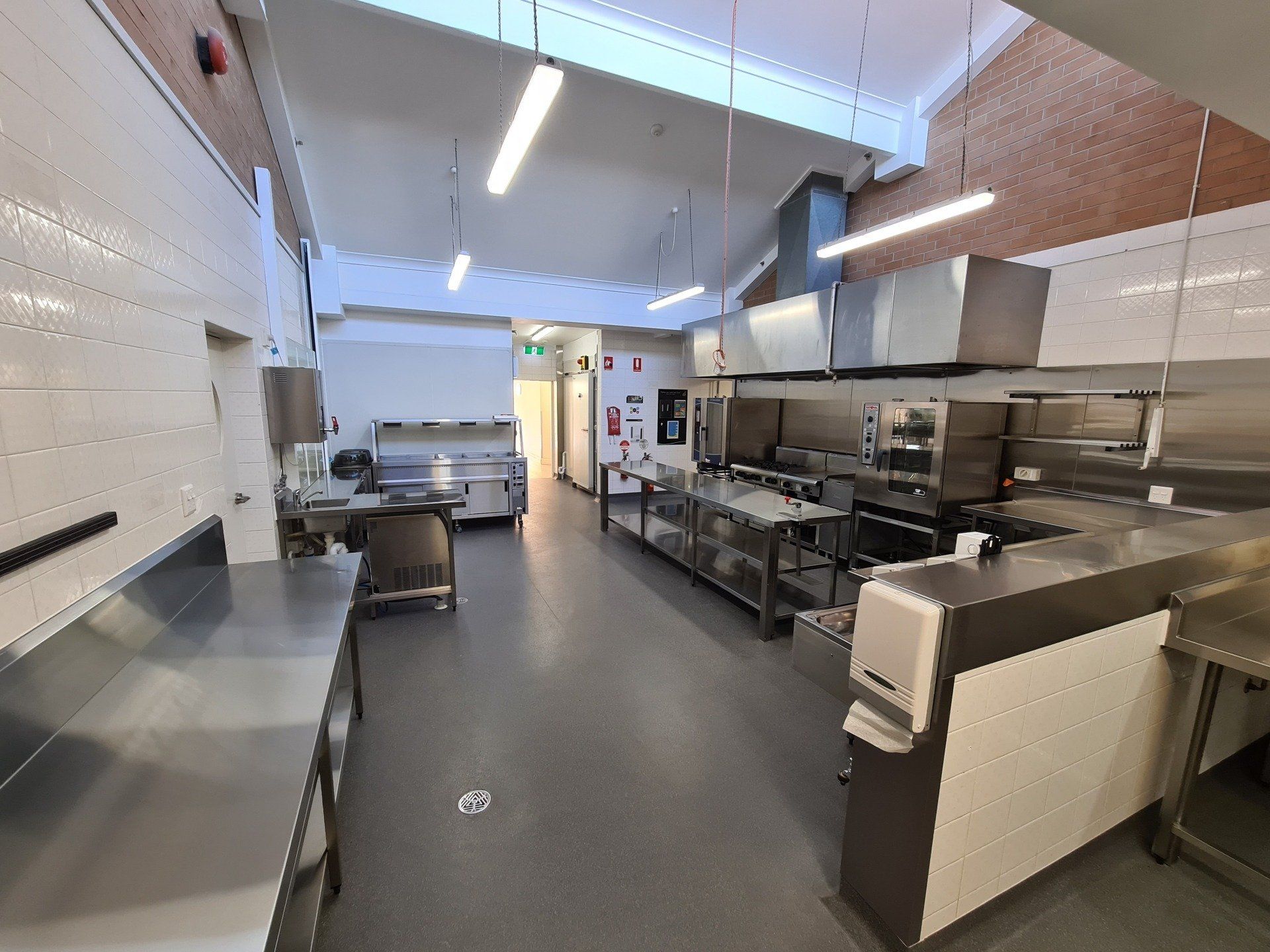 A large kitchen with a lot of stainless steel appliances and counter tops.