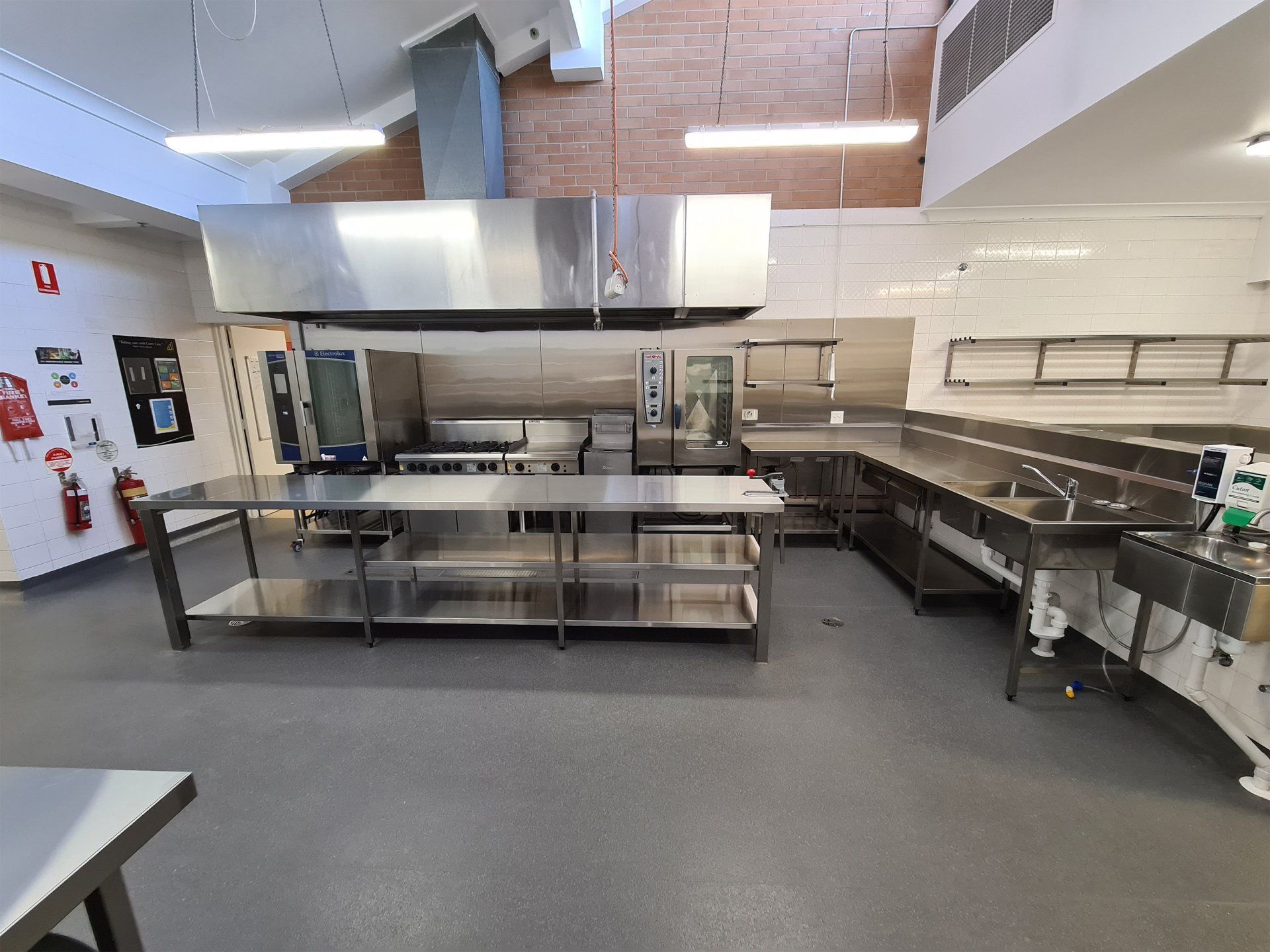 A large kitchen with a lot of stainless steel appliances and counter tops.