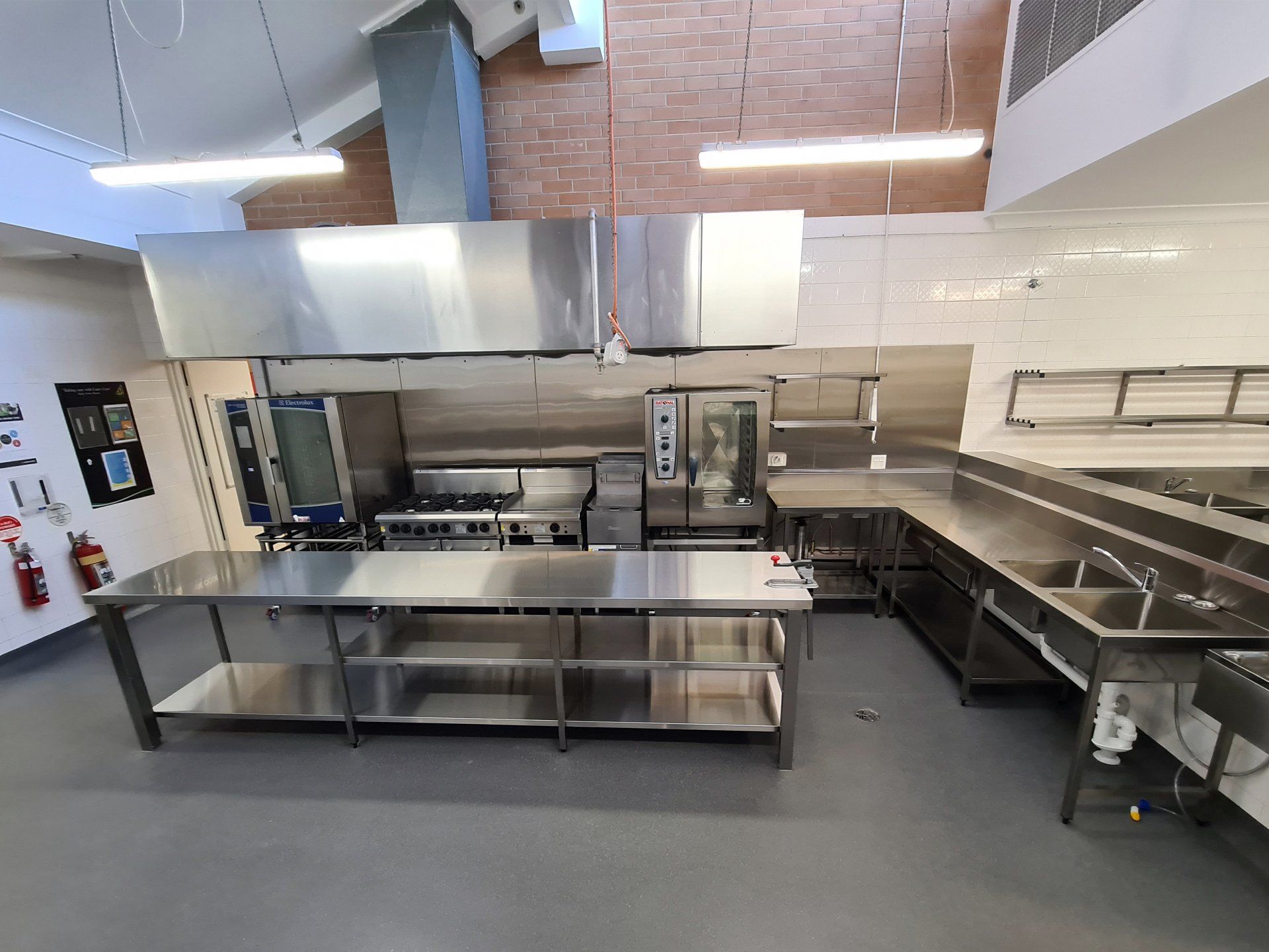 A large kitchen with stainless steel appliances and counter tops.