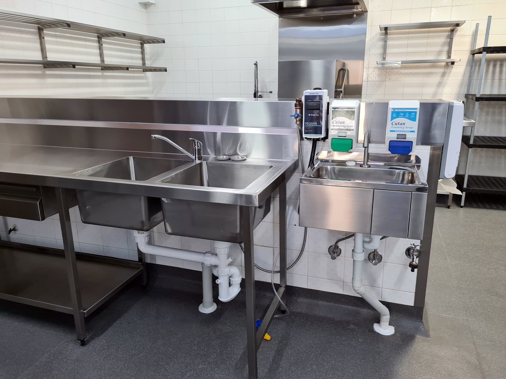 A kitchen with stainless steel sinks and counters