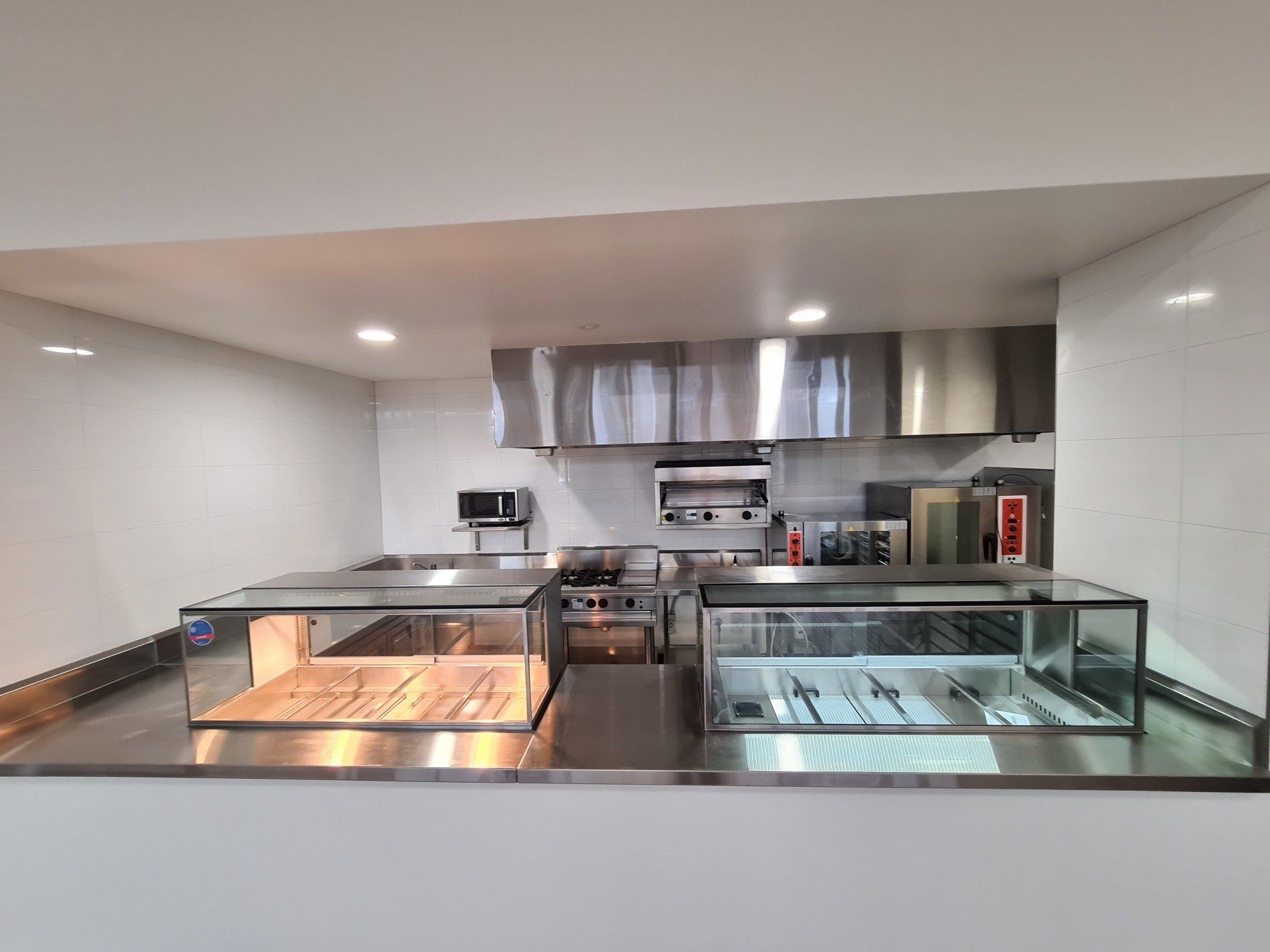 A kitchen with stainless steel appliances and a glass display case.