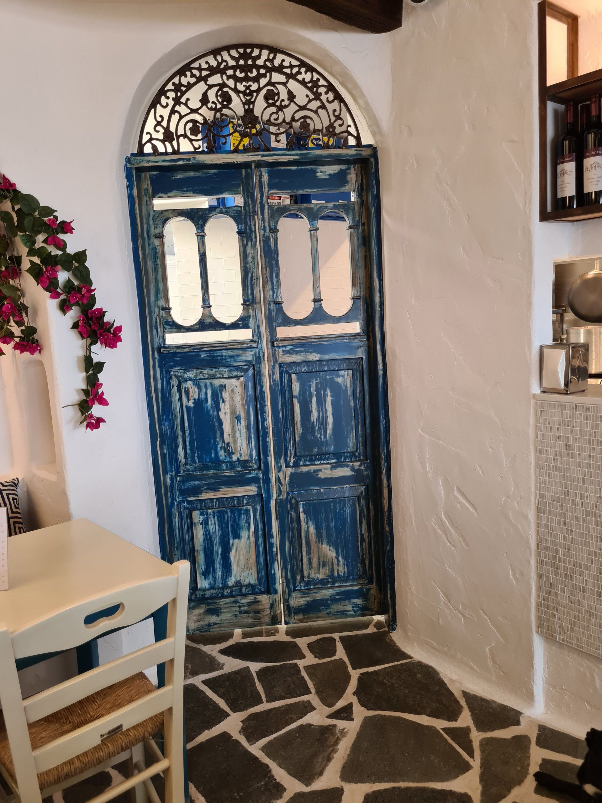 A room with a table and chairs and a blue door
