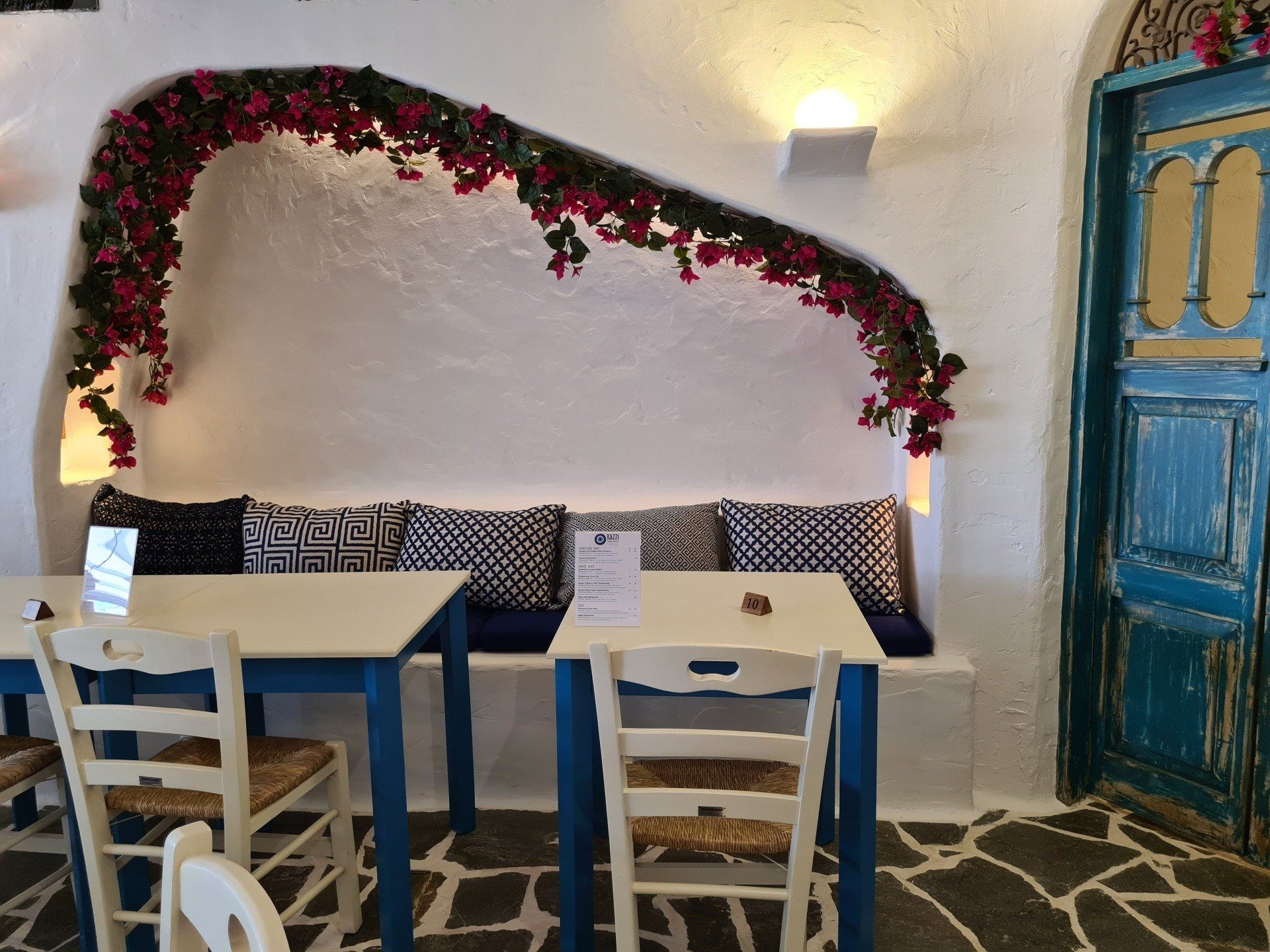 A room with tables and chairs and a blue door