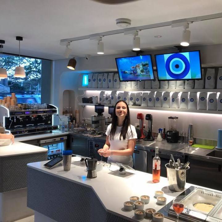 A woman is standing behind a counter in a restaurant
