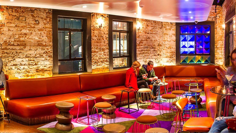 A group of people are sitting at tables in a restaurant.