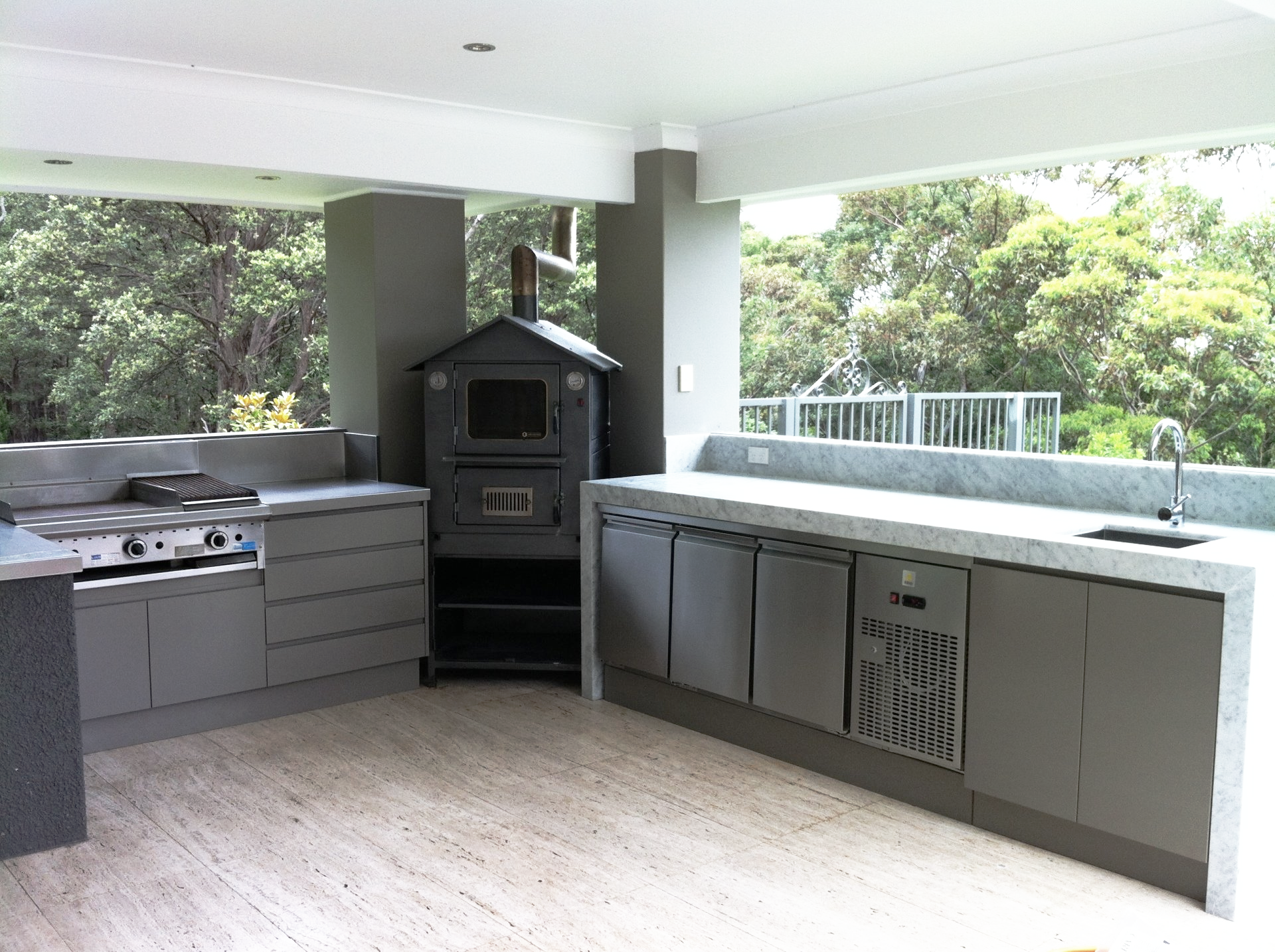 A kitchen with a stove top oven and a sink