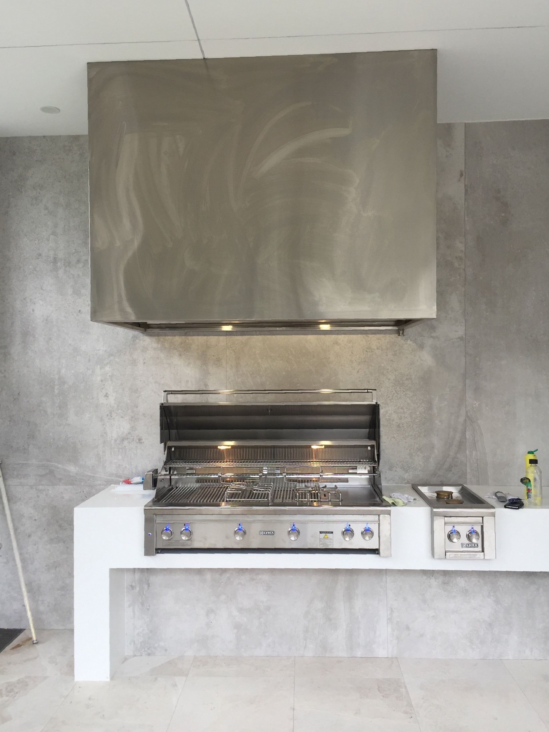 A stainless steel grill is sitting on top of a counter in a kitchen.