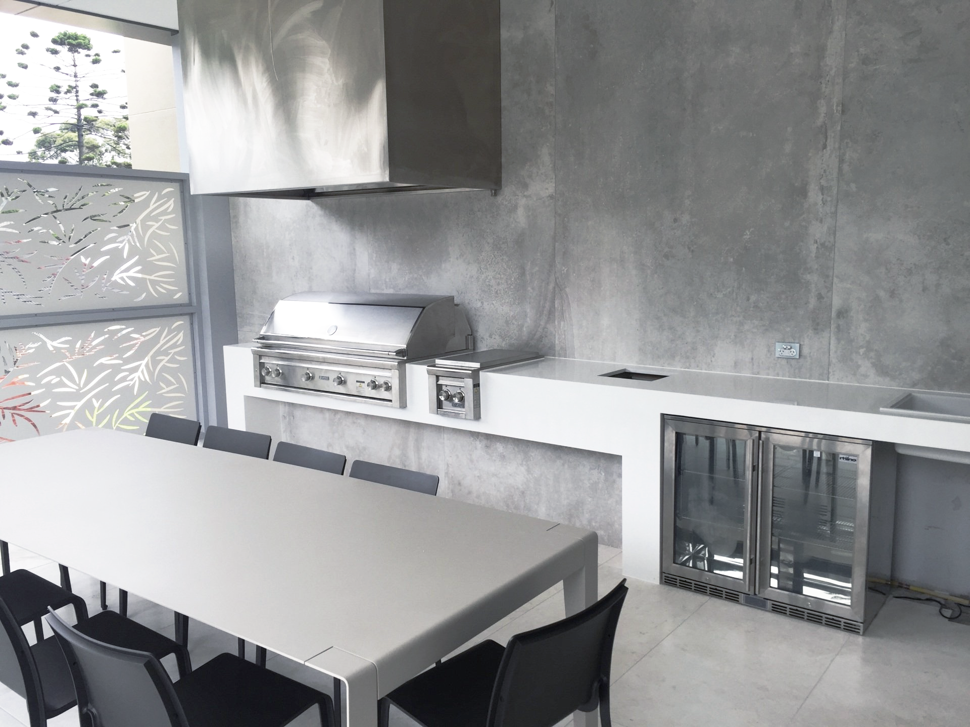 A kitchen with a table and chairs and a grill