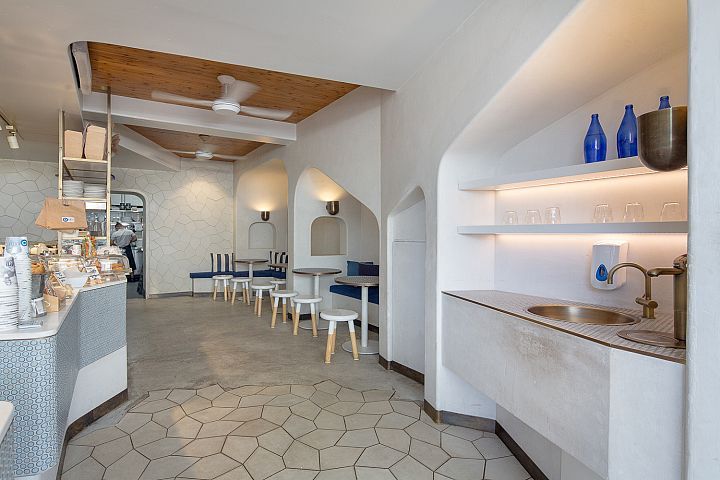 A restaurant with tables and chairs and a sink.