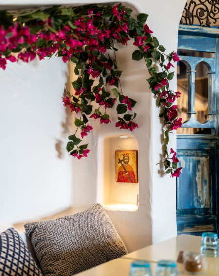 A white wall with pink flowers hanging from it