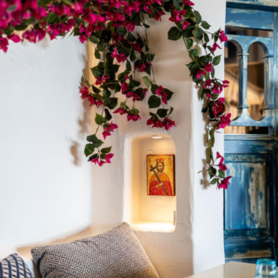 A white wall with pink flowers hanging from it