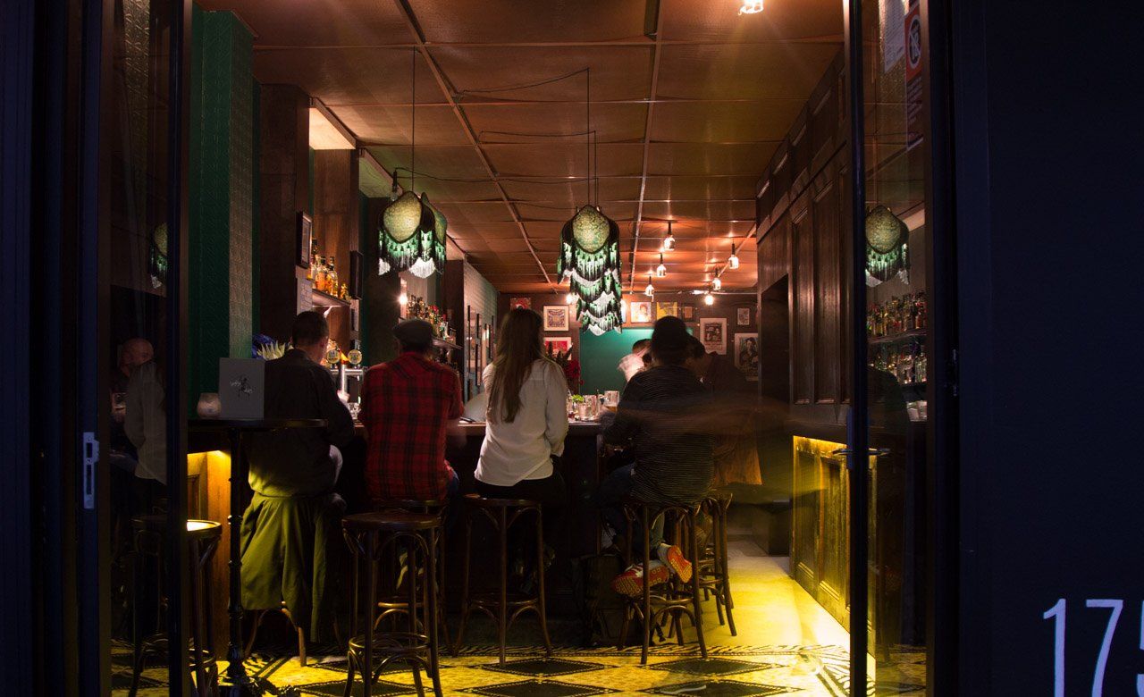 A group of people are sitting at a bar in a restaurant.