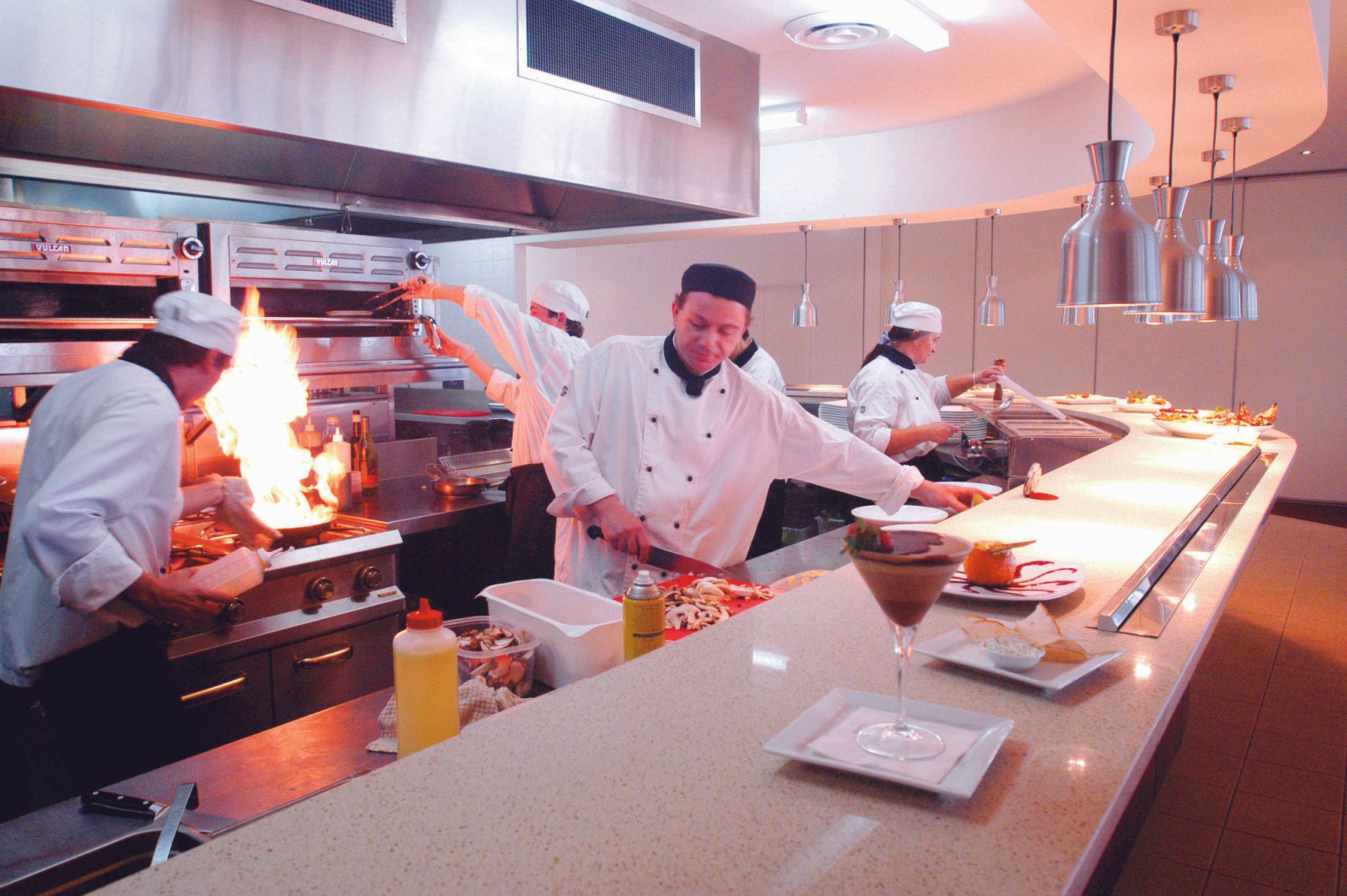 A group of chefs are preparing food in a kitchen