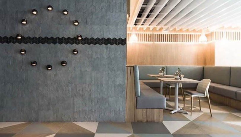 A restaurant with tables and chairs and a clock on the wall.