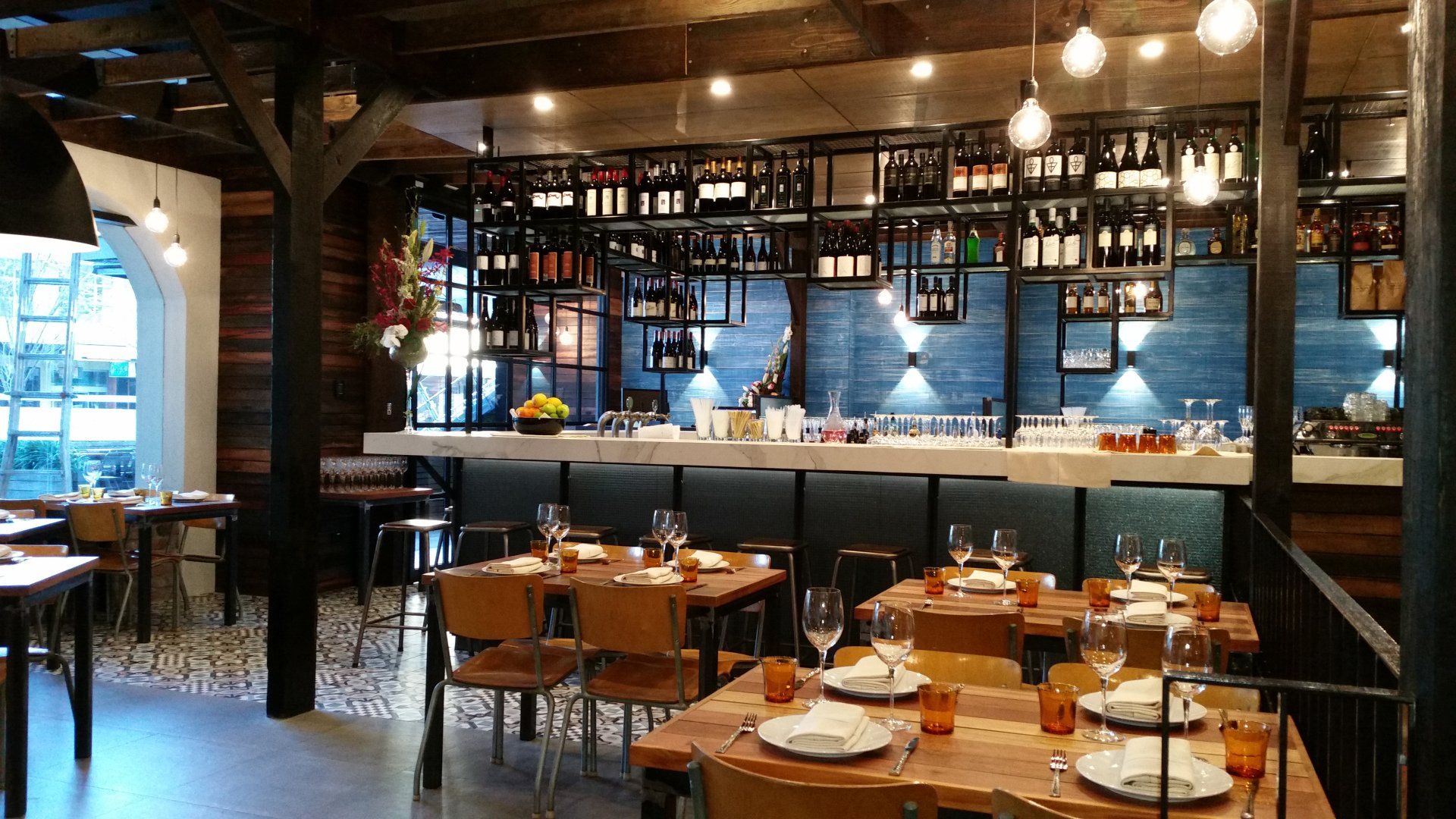 A restaurant with tables and chairs and a bar.