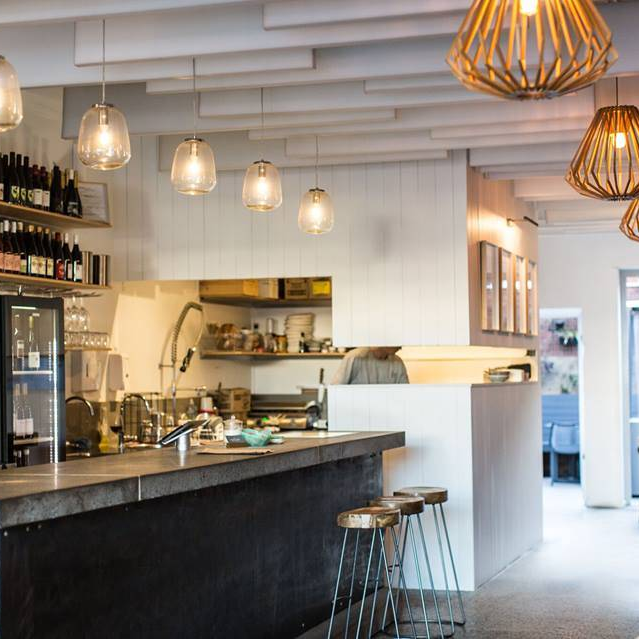 A restaurant with a long counter and stools