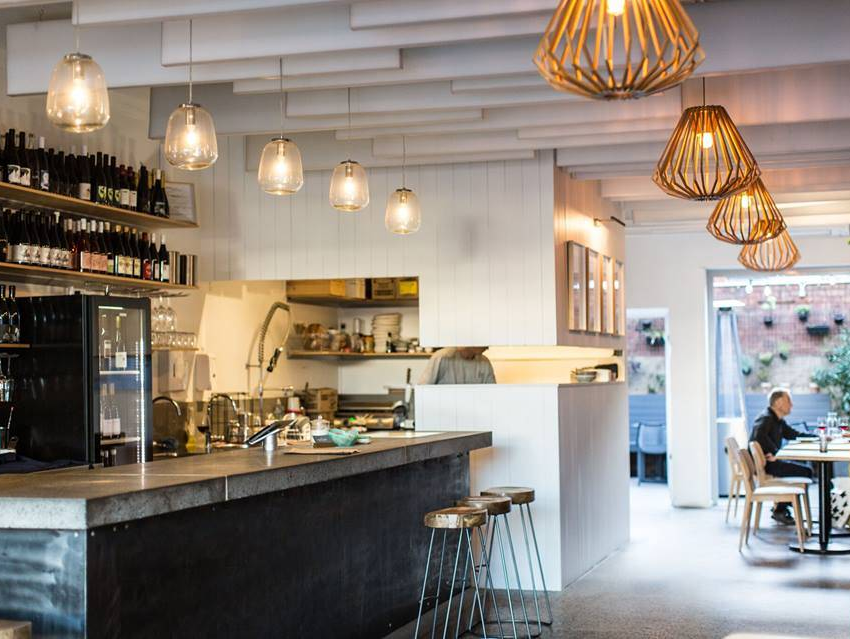 A man is sitting at a table in a restaurant.