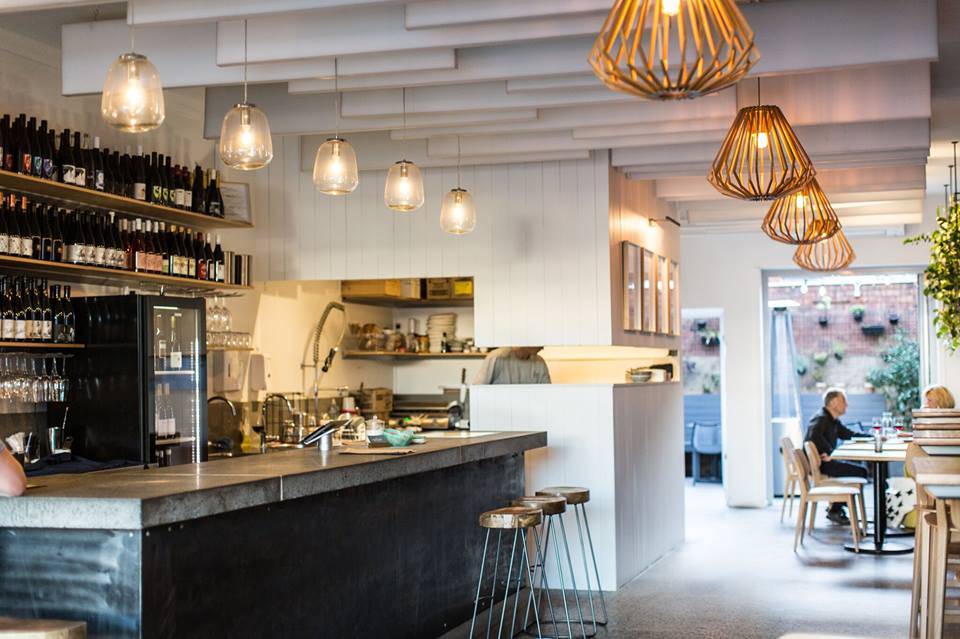 A man is sitting at a table in a restaurant.