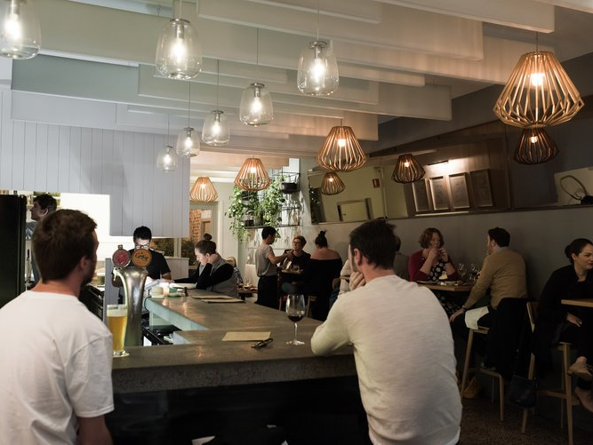 A group of people are sitting at tables in a restaurant