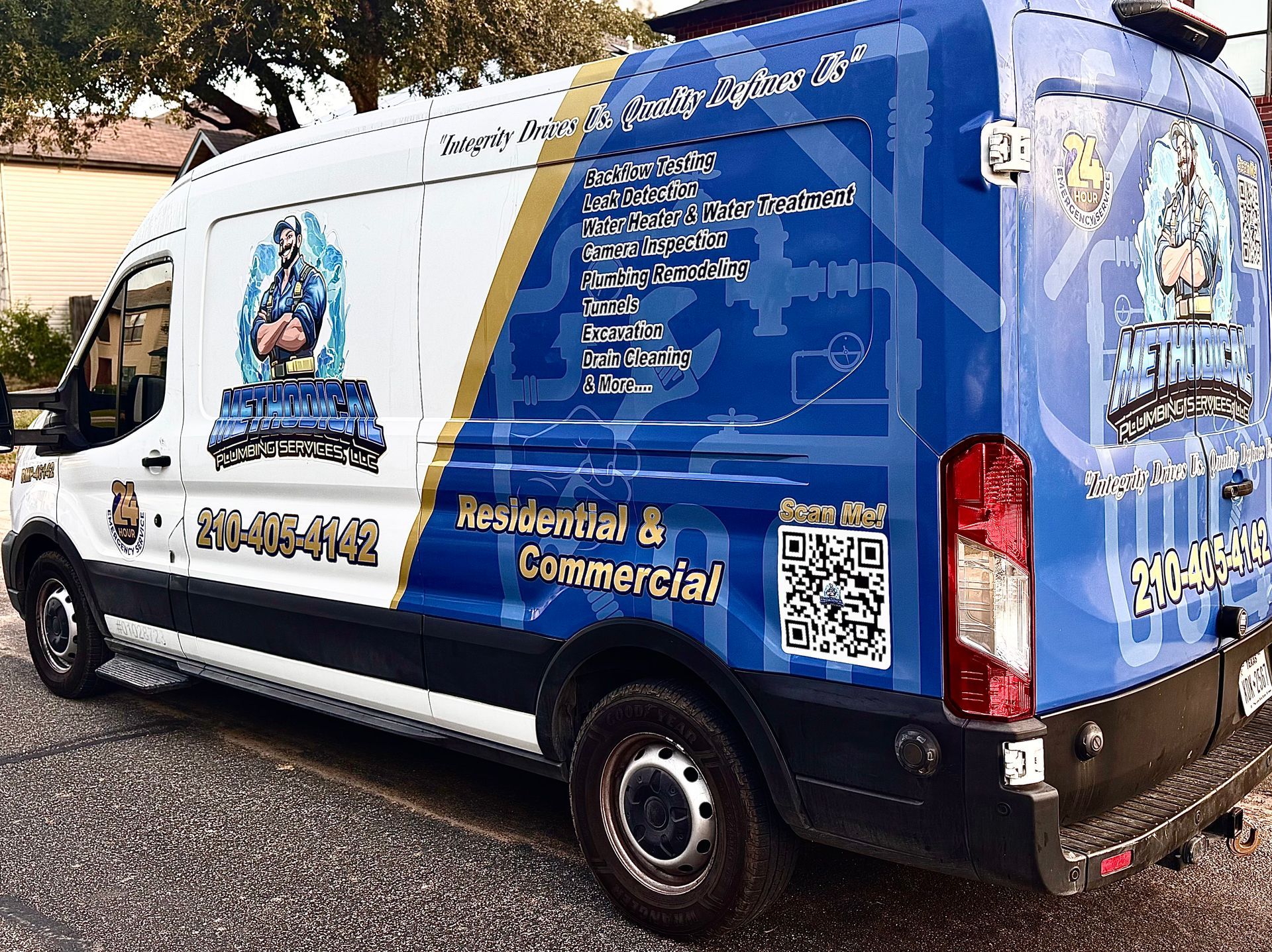 Van parked near a tent under a cloudy sky. Buildings and trees are in the background.