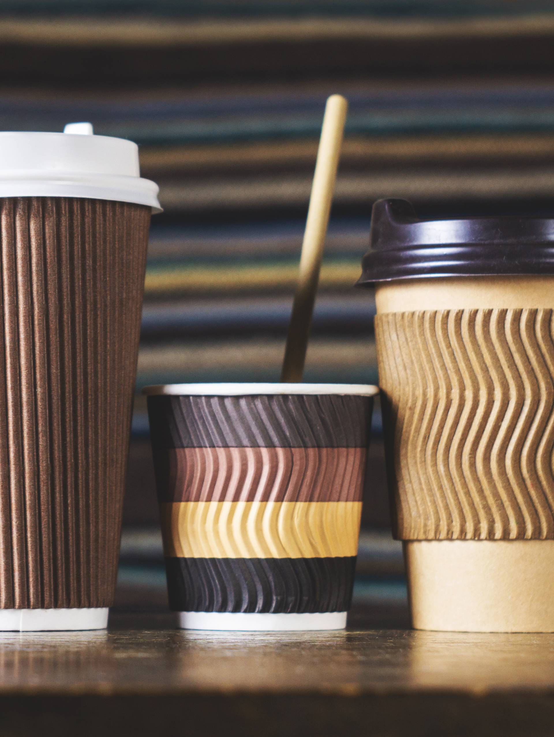 Three cups of coffee are lined up on a table