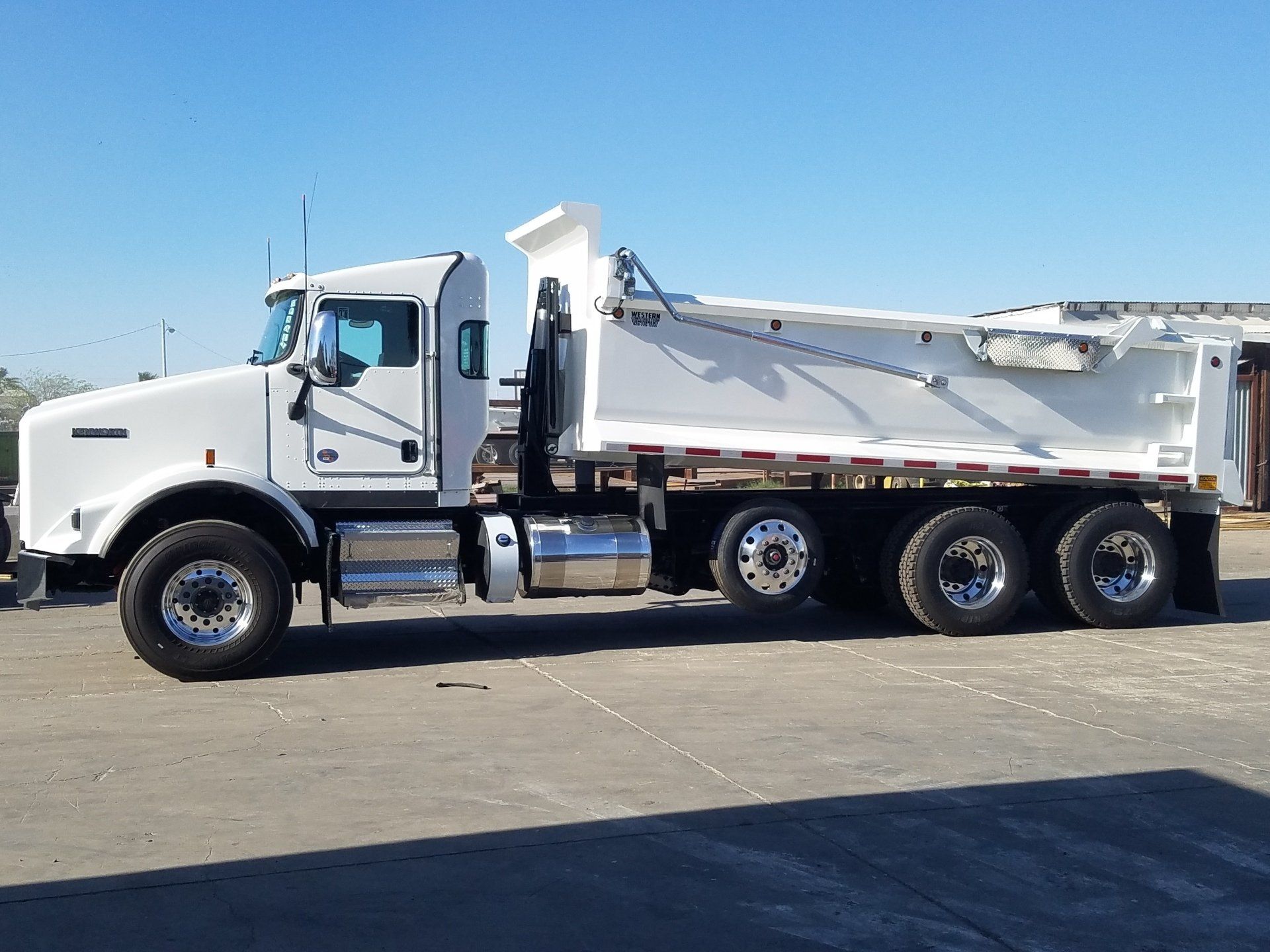 A white dump truck is parked in a parking lot.