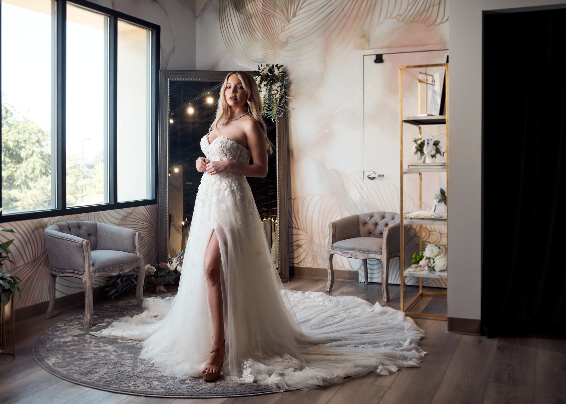 A woman in a wedding dress is standing in front of a mirror in a room.