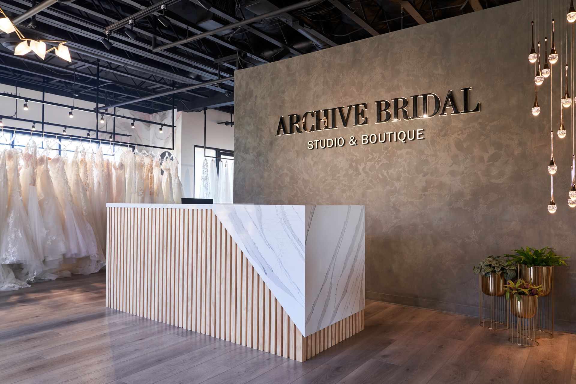 A reception desk in a bridal store with a sign on the wall.
