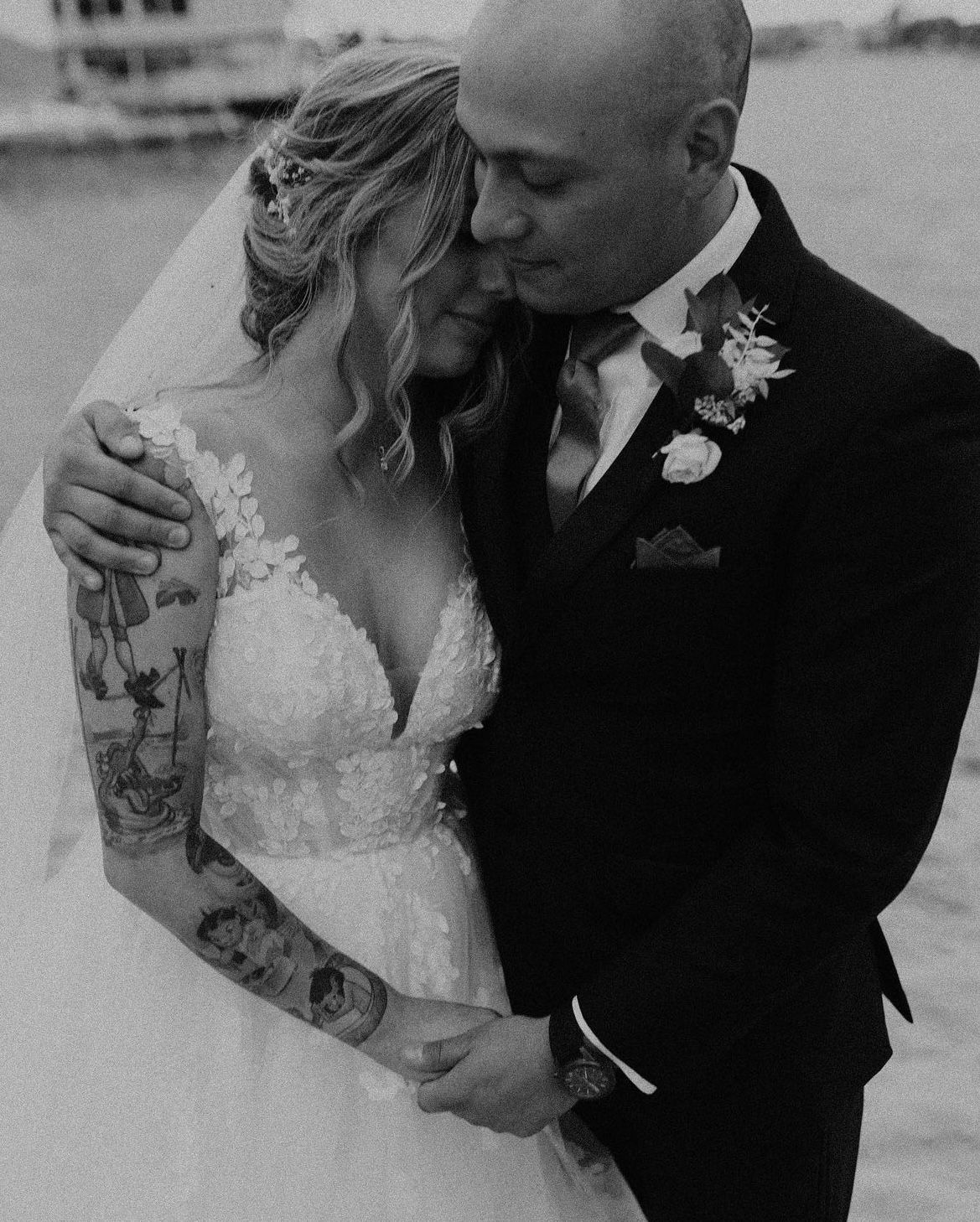 A bride and groom are posing for a black and white photo on their wedding day.
