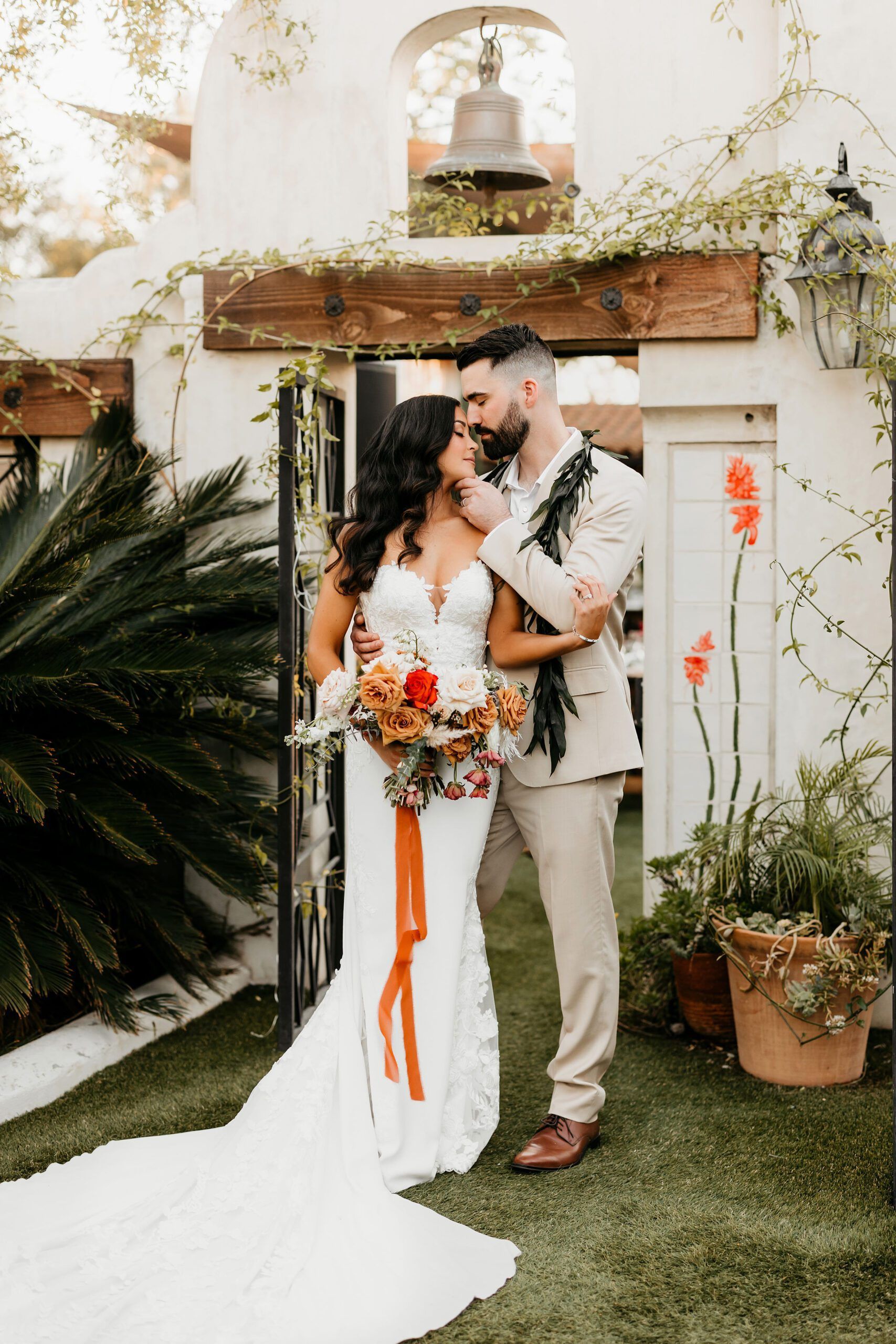 A bride and groom are posing for a picture in front of a building.