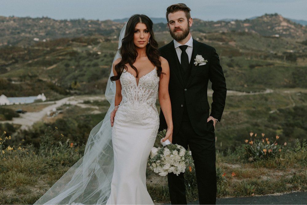 A bride and groom are posing for a picture on their wedding day.