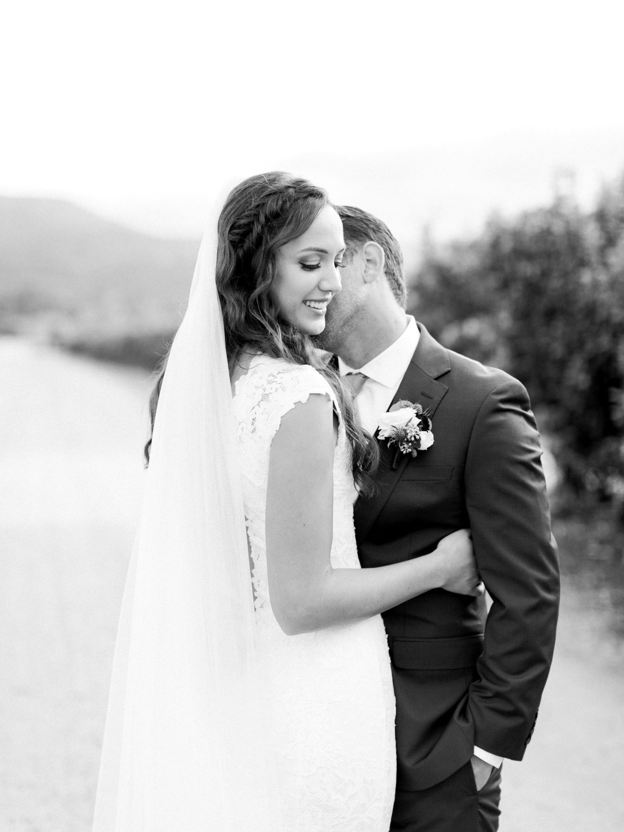 A bride and groom are posing for a black and white photo.