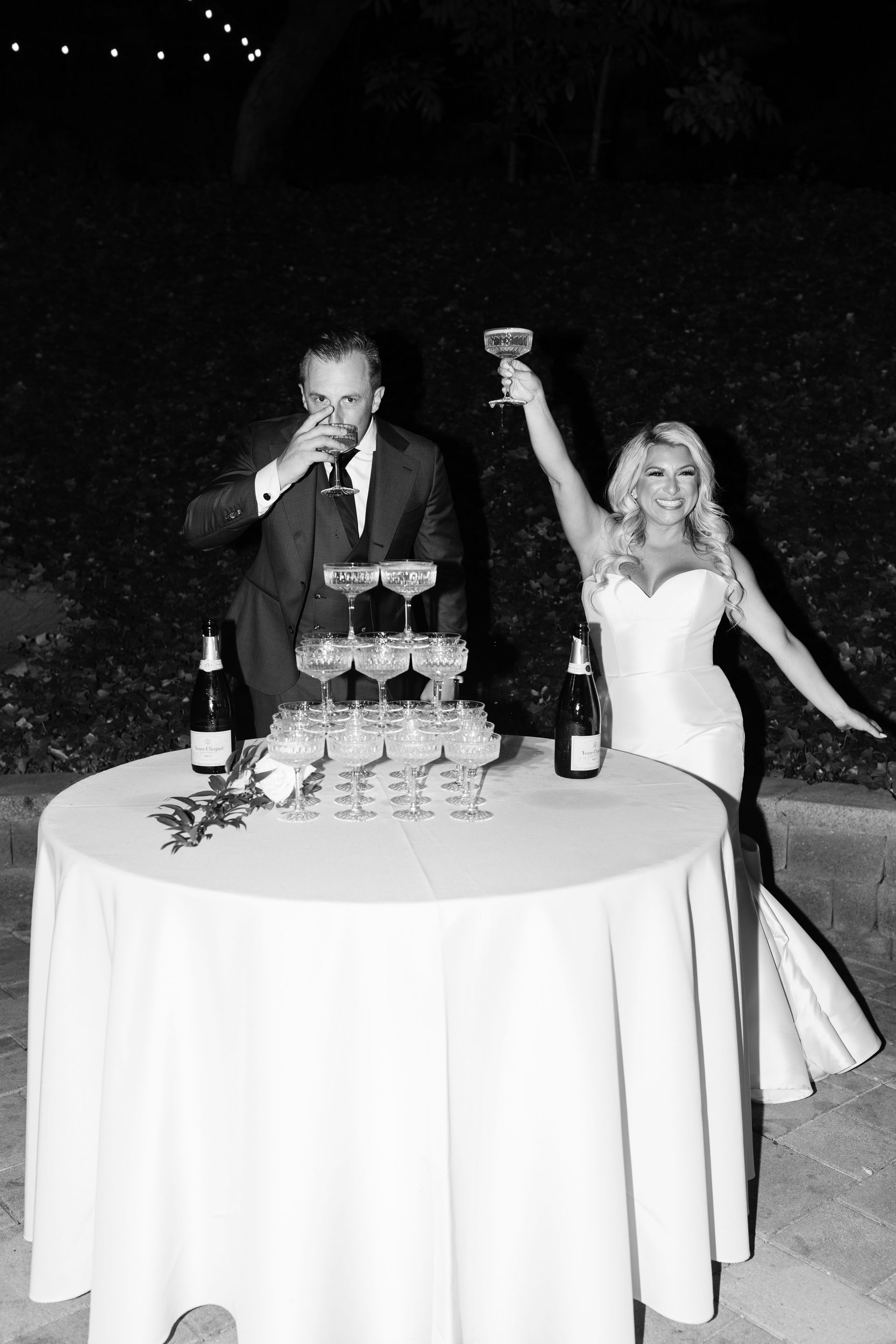 A bride and groom are toasting with champagne at their wedding reception.