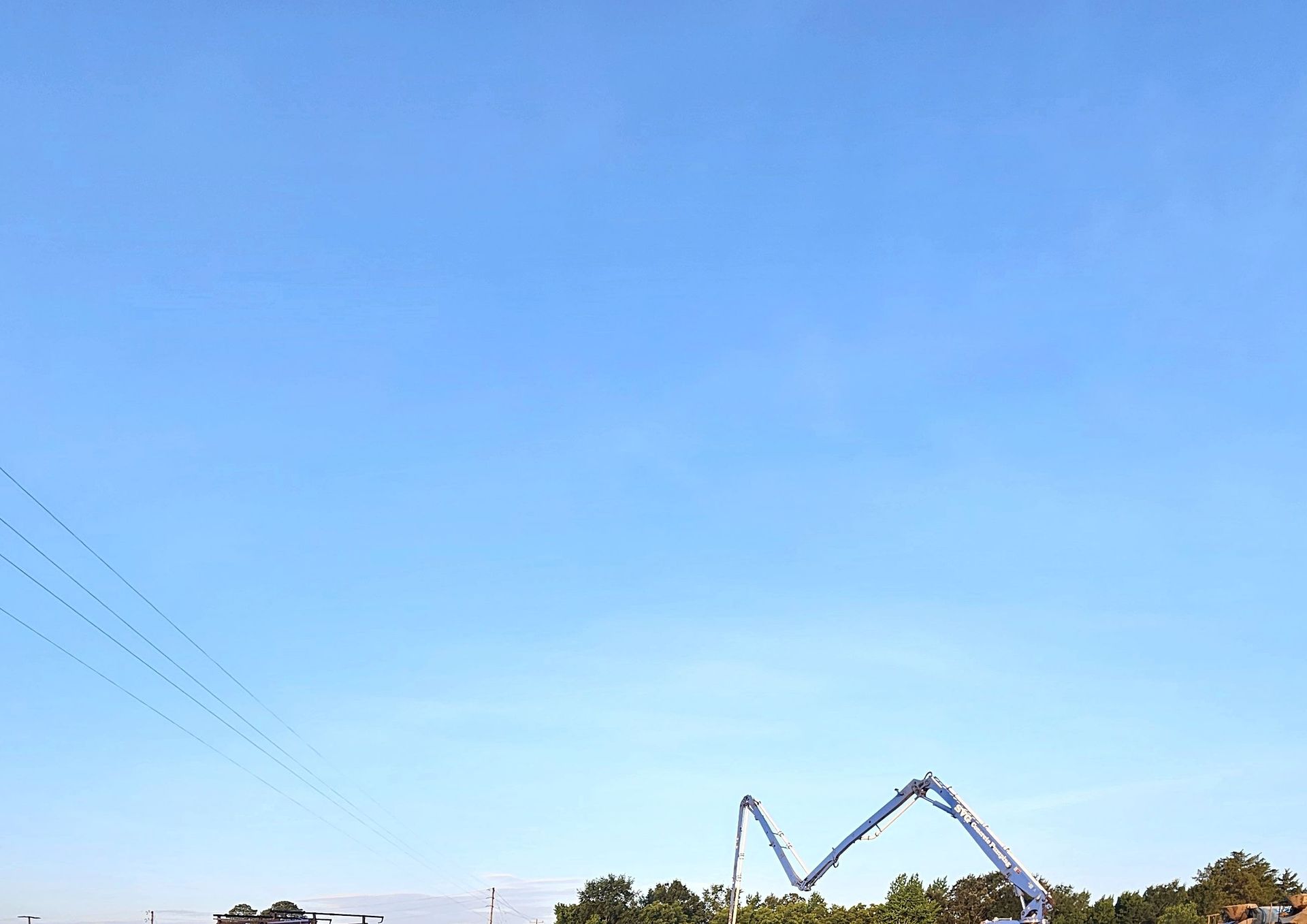 A concrete pump is being used to pump concrete into a field.