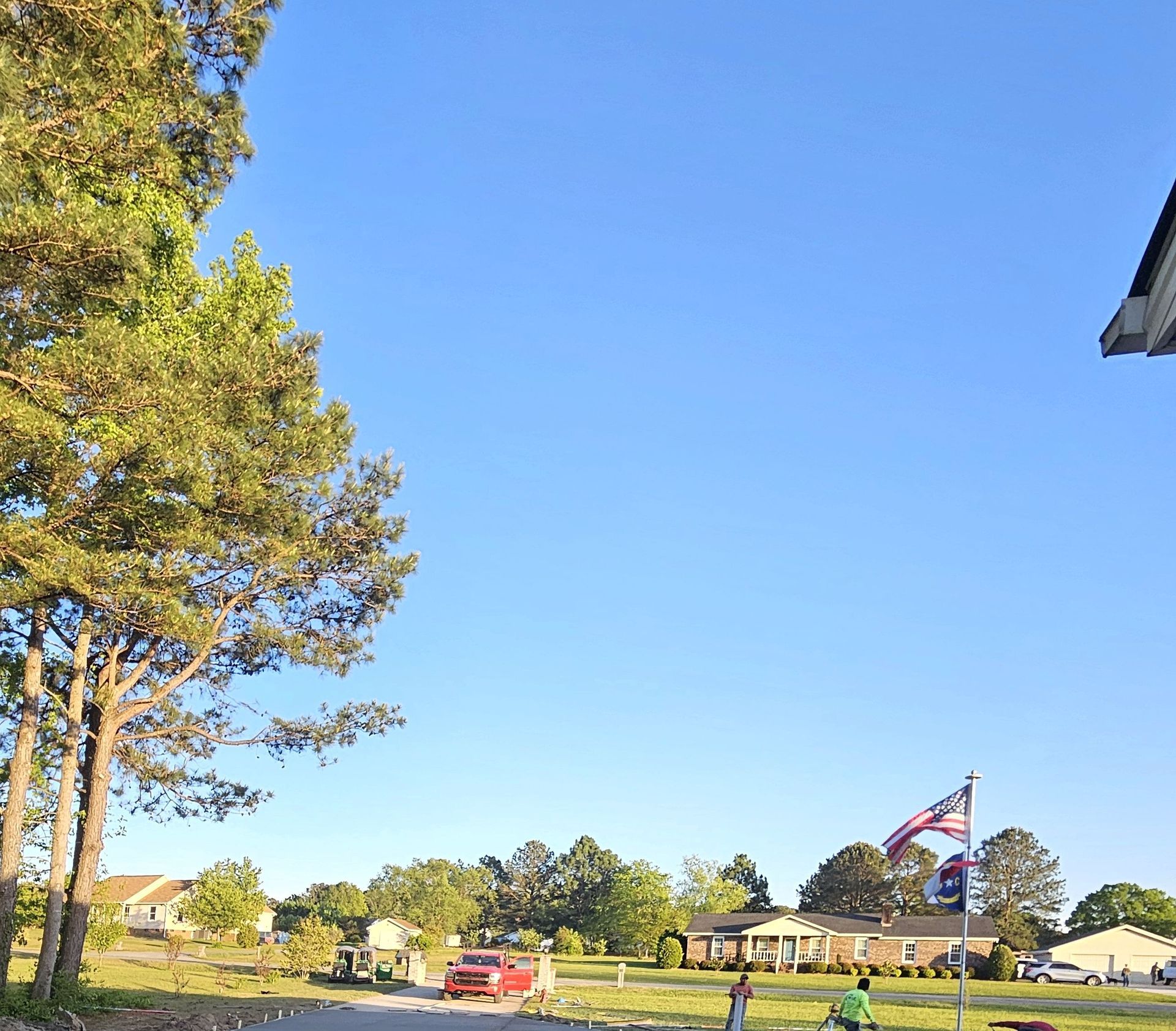 A group of people standing in front of a house with an american flag on a pole