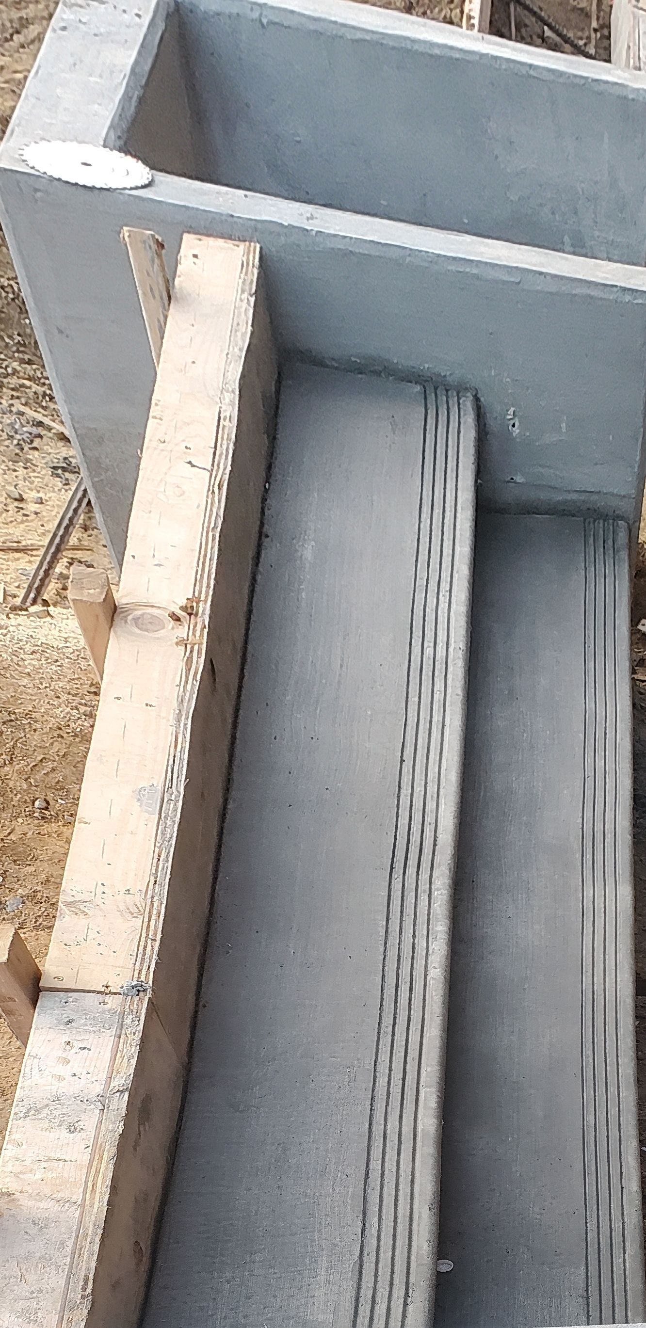 A concrete staircase is being built next to a brick wall.