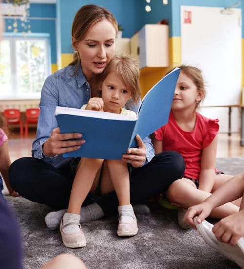 Teacher Reading a Book with Kids — St. Avenel, NJ — Pumpkin Patch Child Care Centers