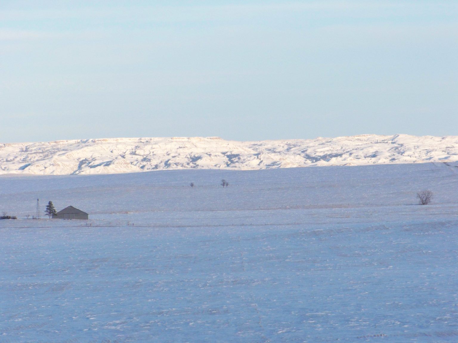 A large body of water surrounded by snow covered mountains.