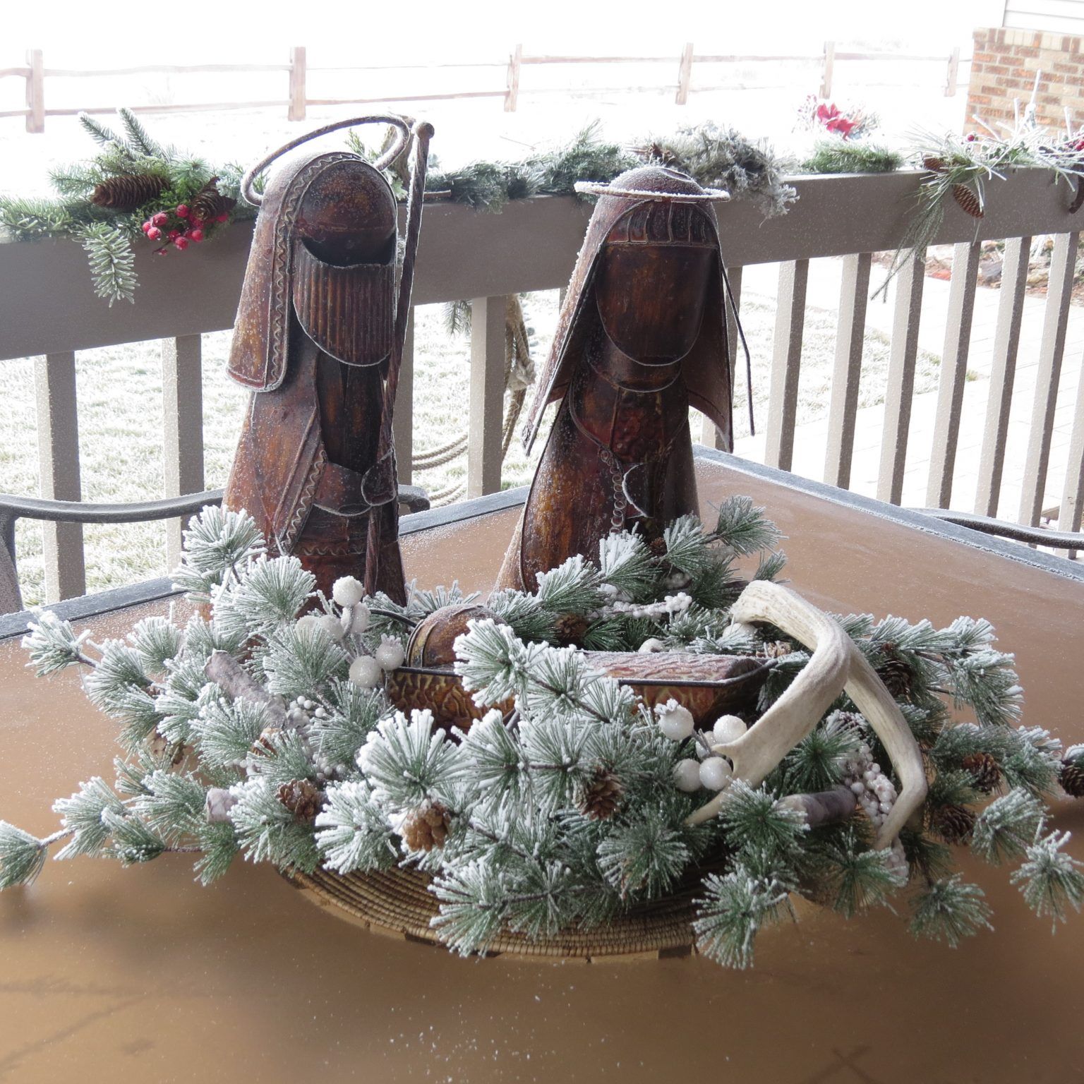 A nativity scene is on a table with a wreath