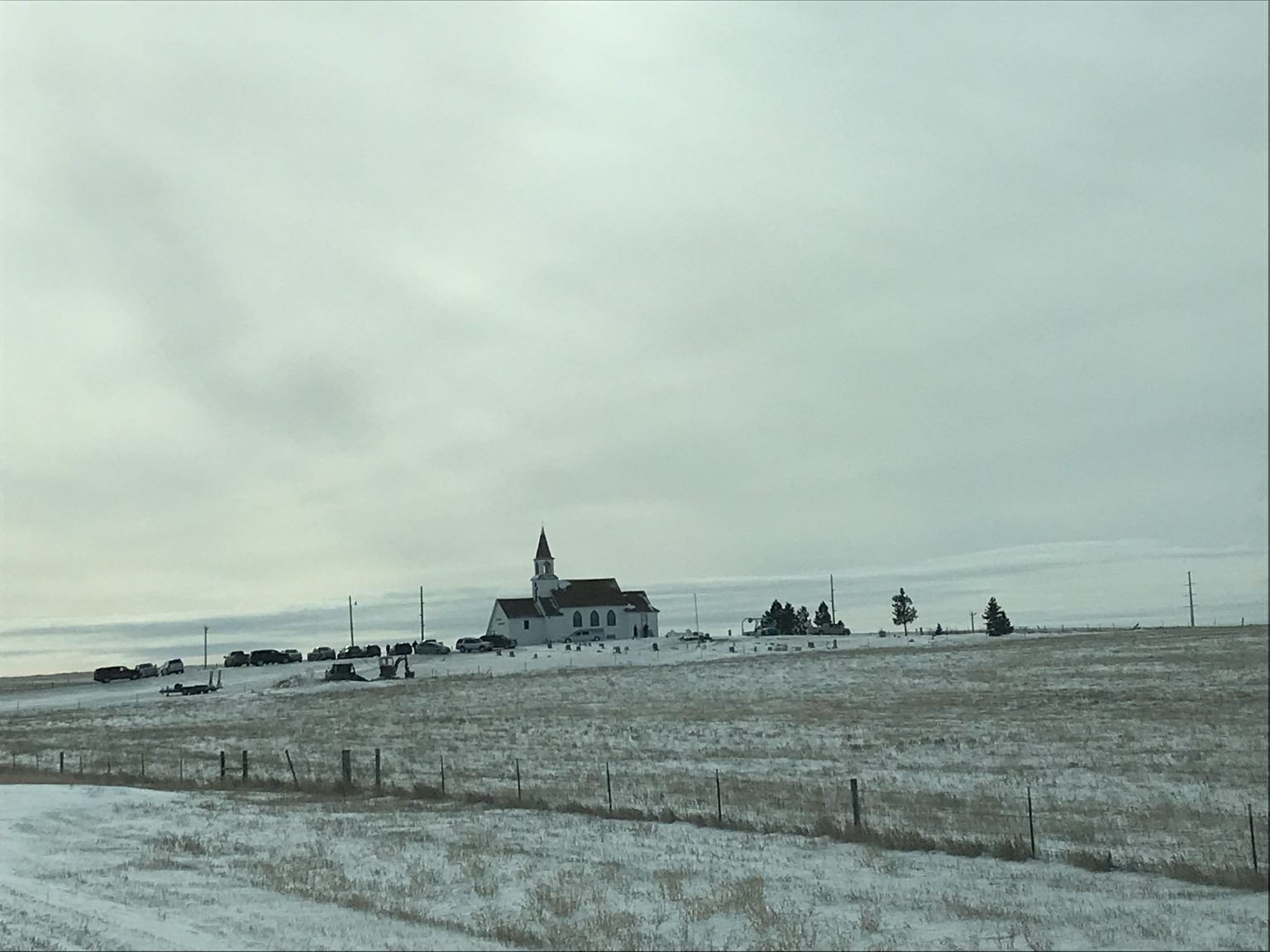 A snowy field with a church in the distance