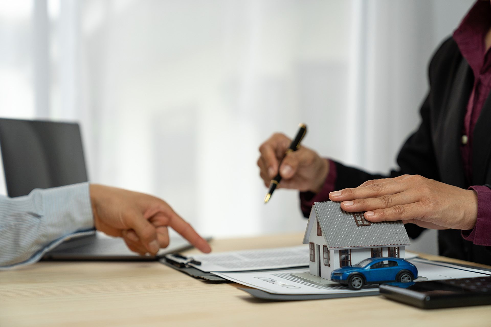 A person consulting with a home insurance agency to finalize a comprehensive policy for a house.