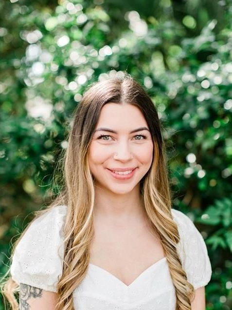 A man is holding a small dog in his arms.