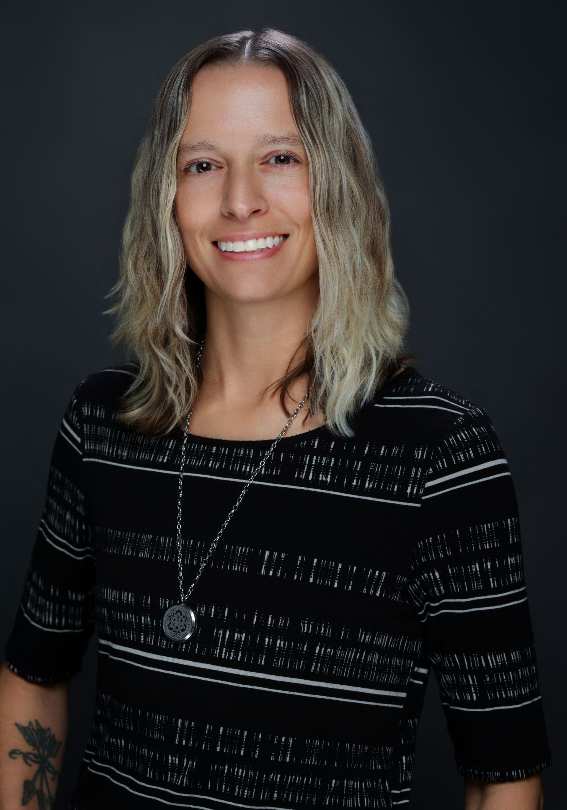 A woman is smiling in front of a sign that says insf ac 73.
