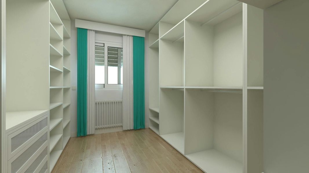 Empty walk-in closet with white shelves and drawers, a window with teal curtains, and wooden floors.