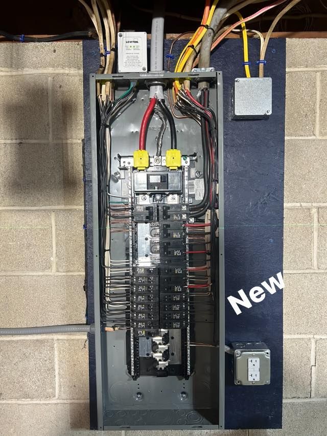 A very messy electrical box is hanging from the ceiling.